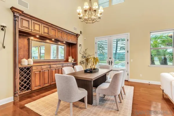 a dining room with furniture a chandelier and wooden floor