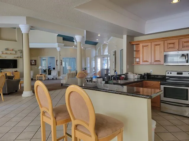 a dining hall with couches a dining table and chairs with wooden floor