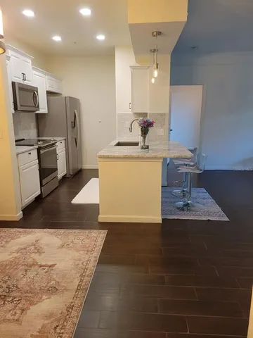 a large kitchen with kitchen island a sink stainless steel appliances and cabinets