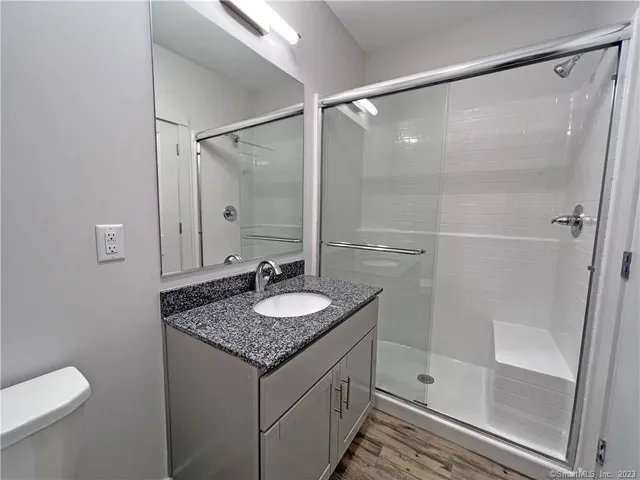 a bathroom with a granite countertop sink toilet and shower