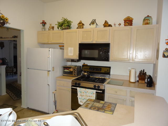 109 Castaway Road Manahawkin, NJ 08050 - Photo 8 of 25 a kitchen with a refrigerator and a stove top oven