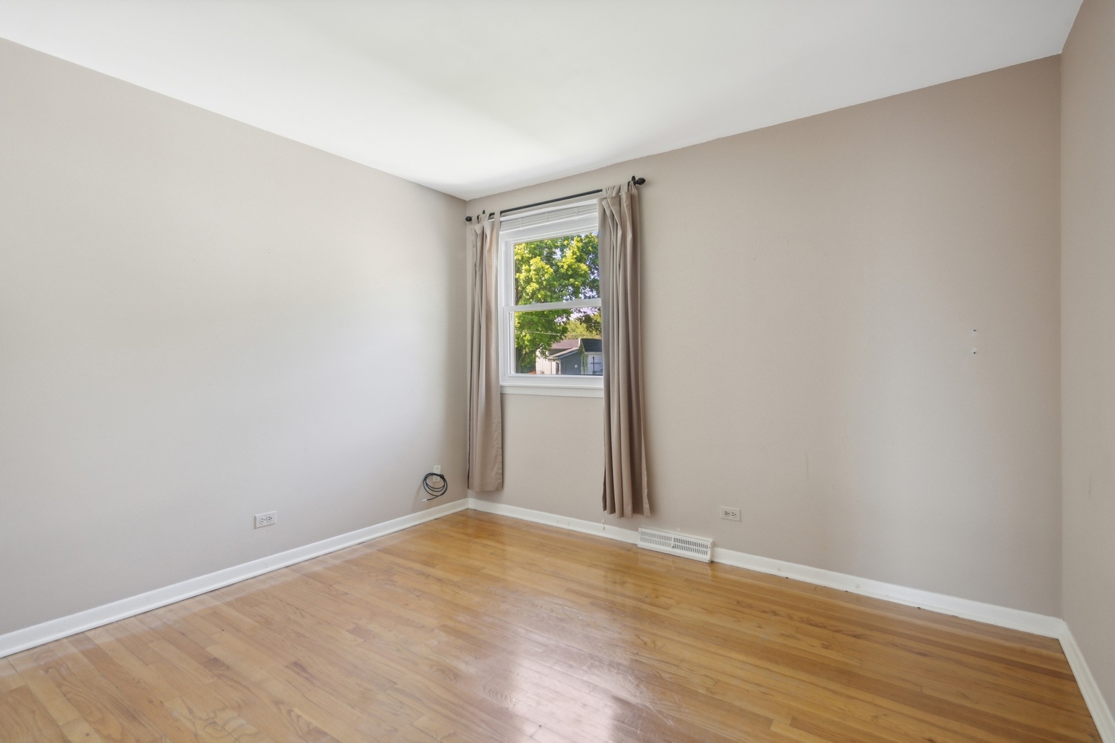 1025 Timber Lane Darien, IL 60561 - Photo 8 of 17 a view of an empty room with wooden floor and a window
