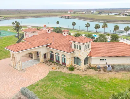 an aerial view of residential houses with outdoor space and ocean view