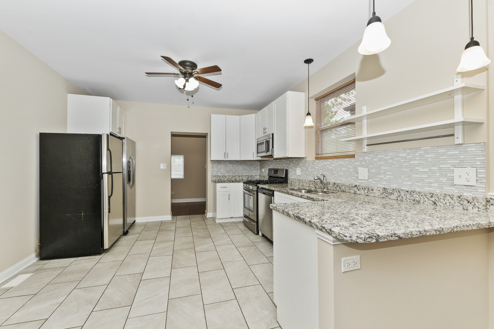 8317 South Merrill Avenue Chicago, IL 60617 - Photo 6 of 23 a kitchen with a sink a refrigerator and cabinets