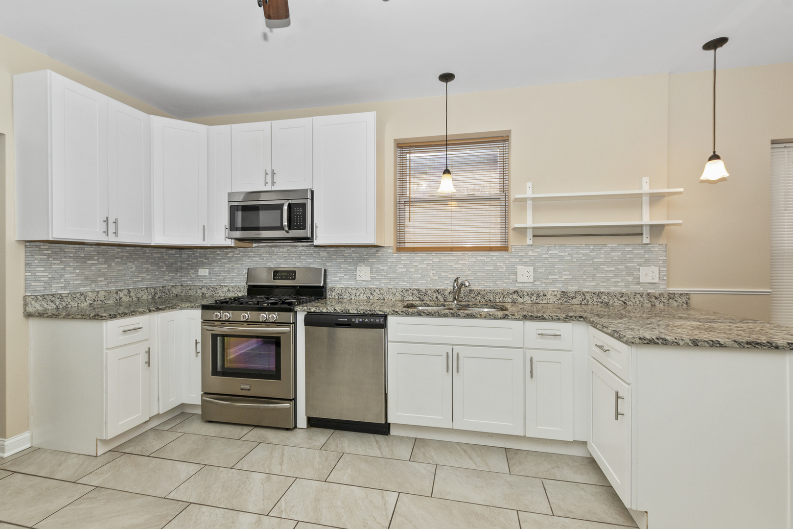 8317 South Merrill Avenue Chicago, IL 60617 - Photo 7 of 23 a kitchen with granite countertop white cabinets white stainless steel appliances with a sink and dishwasher