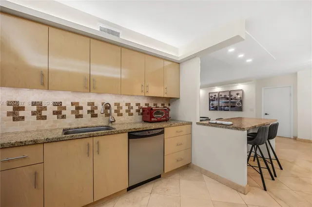 a kitchen with granite countertop sink and white cabinets