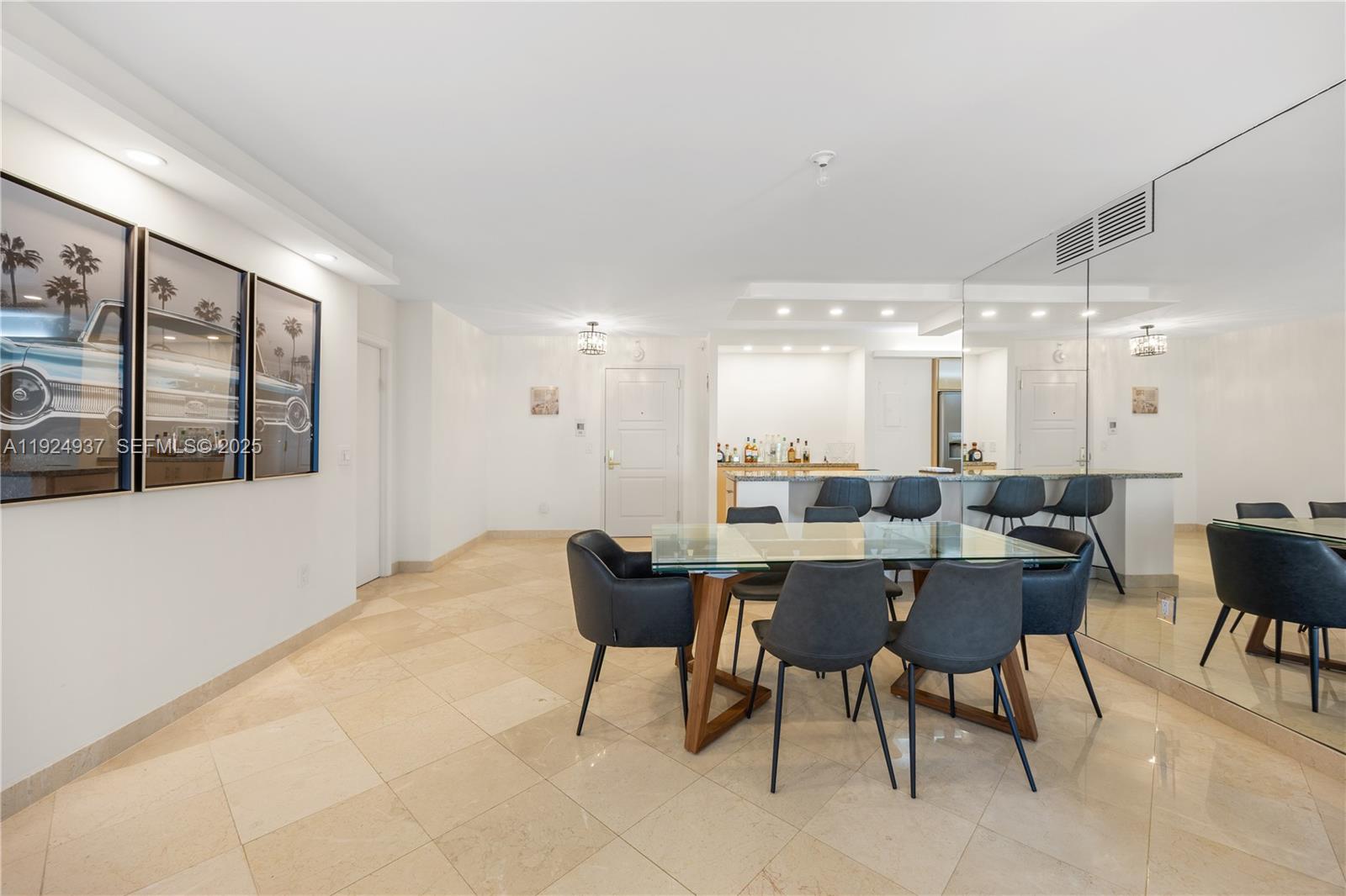 9801 Collins Avenue, Unit 10G Bal Harbour, FL 33154 - Photo 16 of 34 a dining hall with stainless steel appliances kitchen island granite countertop a table and chairs