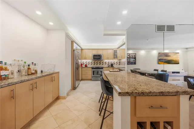 a kitchen with stainless steel appliances granite countertop a sink and a refrigerator