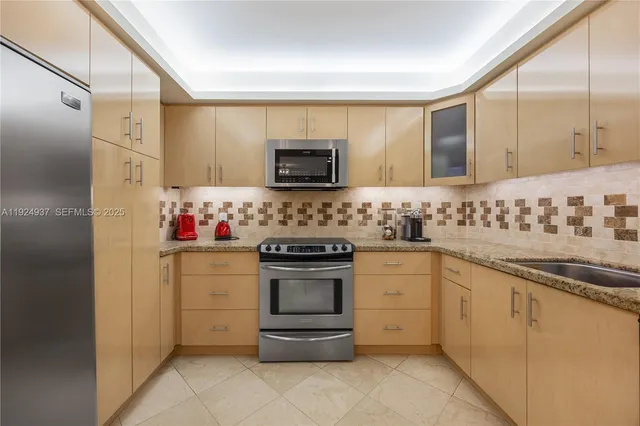 a kitchen with granite countertop white cabinets and stainless steel appliances