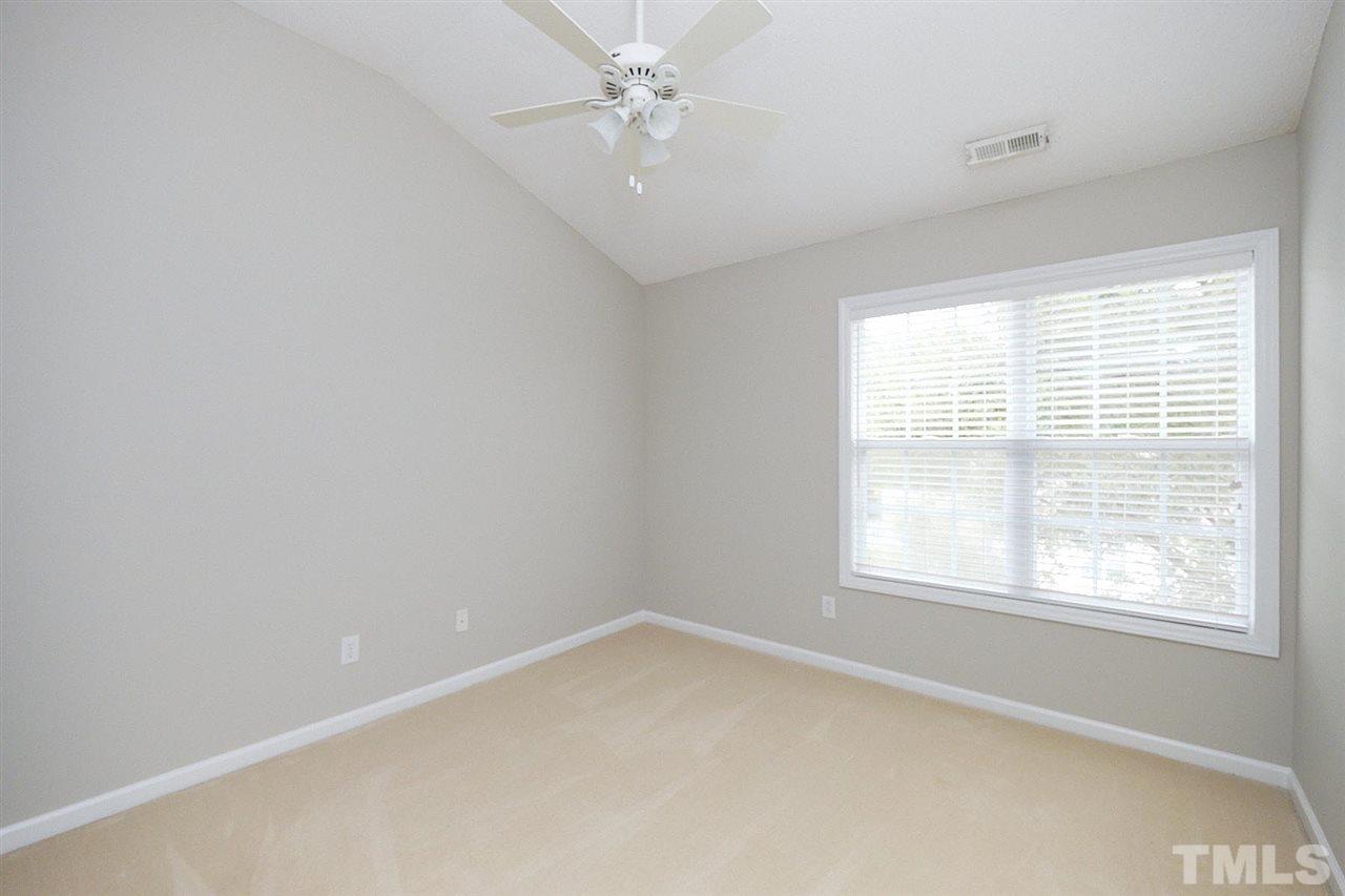 1437 Basinger Court Raleigh, NC 27612 - Photo 22 of 30 Bedroom 2 on 2nd floor with vaulted ceiling, ceiling fan, and double windows.