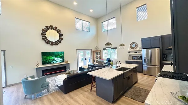 a living room with kitchen island furniture and a flat screen tv