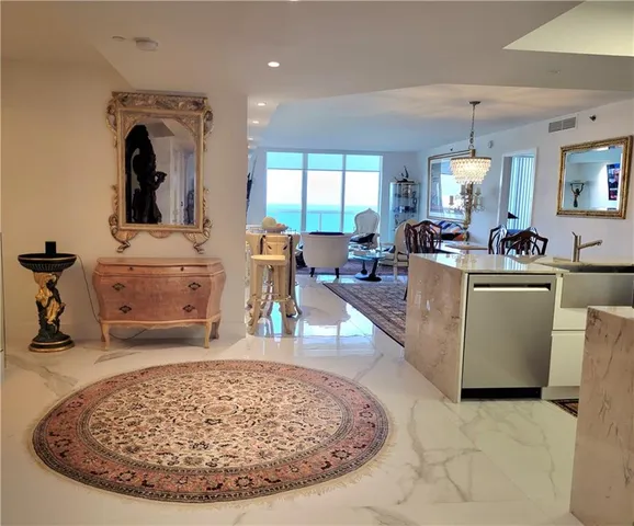 a living room with furniture a fireplace and a chandelier