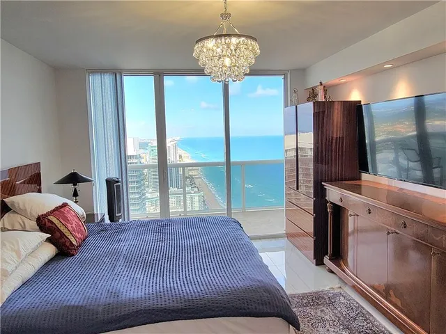 a bedroom with a large bed and a chandelier