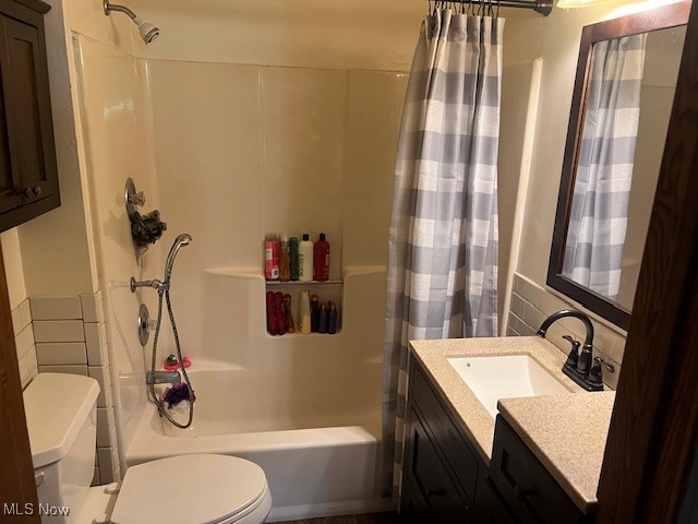 Full bathroom with vanity, shower / bath combination with curtain, and toilet