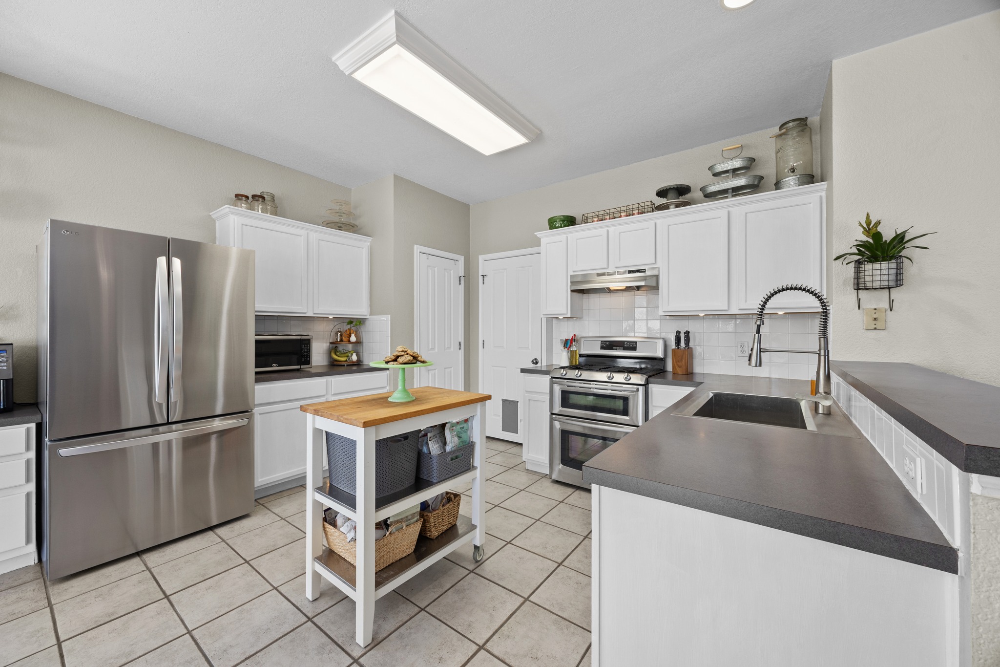 17833 Madden Drive Pflugerville, TX 78660 - Photo 6 of 21 a kitchen with granite countertop a stove oven and refrigerator