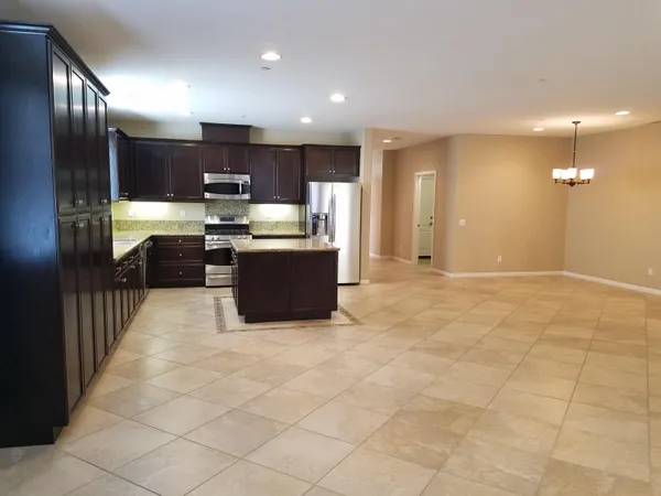 a view of kitchen with stainless steel appliances lots of counter top space cabinets and furniture