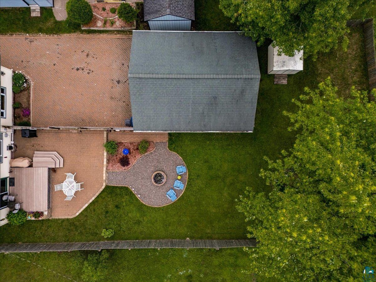 130 West Austin Street Duluth, MN 55803 - Photo 26 of 35 Spacious outdoor living area featuring a large paver patio, wood-finish deck, and circular stone patio with a built-in fire pit