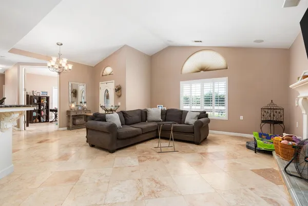 a living room kitchen with furniture and a chandelier