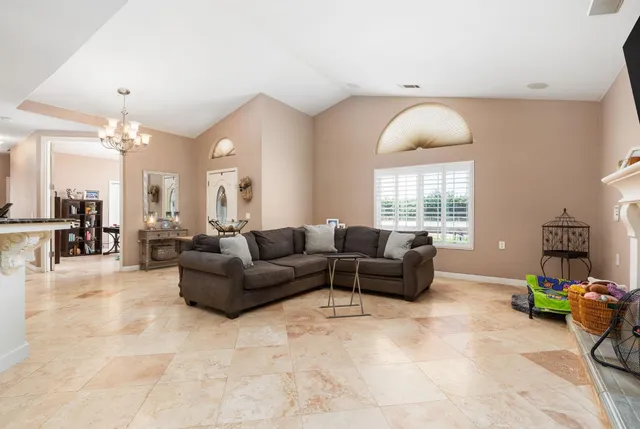 a living room kitchen with furniture and a chandelier