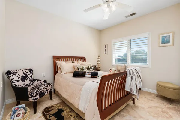 a spacious bedroom with a bed a couch and a flat screen tv