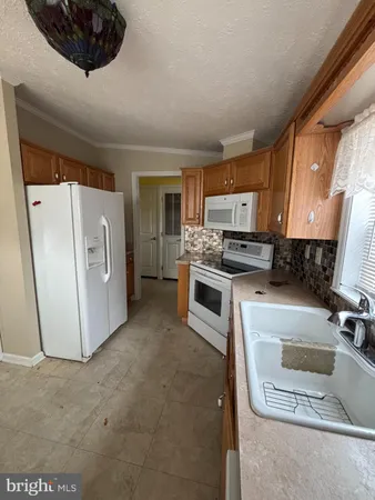 a kitchen with stainless steel appliances a stove a microwave a sink a refrigerator and cabinets