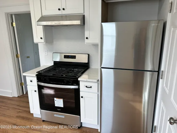 a kitchen with stainless steel appliances granite countertop a refrigerator and a stove