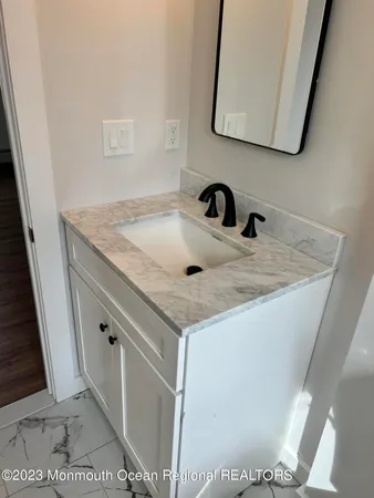 a bathroom with a granite countertop sink and a mirror