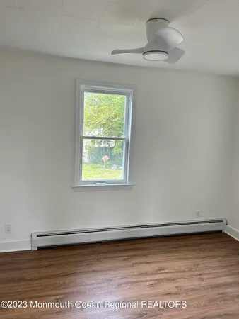 a view of a small space with wooden floor and a window