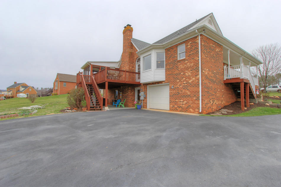 208 Longhill Road Goode, VA 24556 - Photo 11 of 59 a front view of a house with a yard and garage