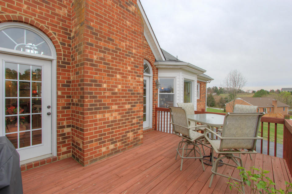 208 Longhill Road Goode, VA 24556 - Photo 14 of 59 a view of a patio with table and chairs with wooden floor and fence