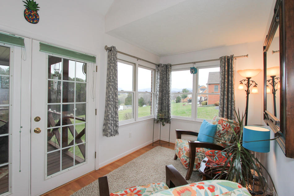 208 Longhill Road Goode, VA 24556 - Photo 38 of 59 a living room with furniture and a floor to ceiling window