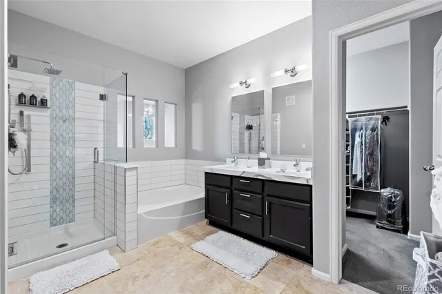 a bathroom with a double vanity sink a toilet and shower