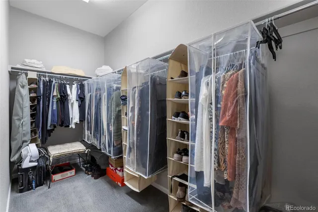 a view of walk in closet with clothes and shoes