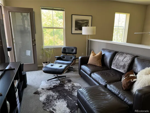 a living room with furniture a window and a flat screen tv