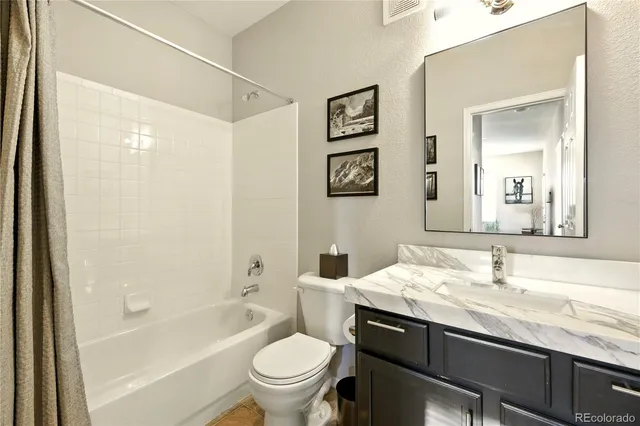 a bathroom with a granite countertop sink toilet and shower
