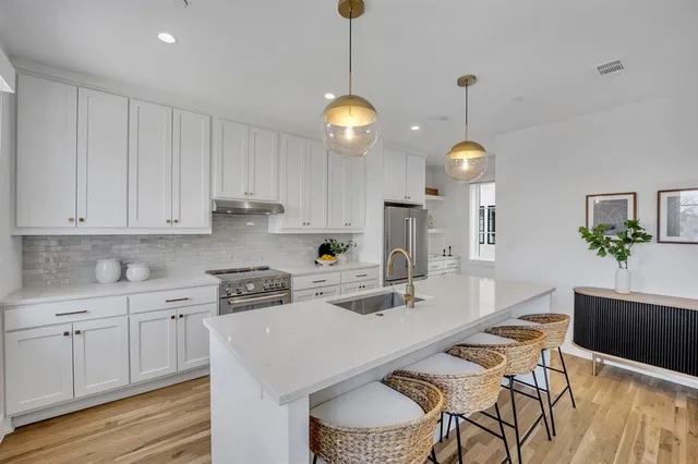 a kitchen with kitchen island granite countertop a sink a counter space appliances and cabinets