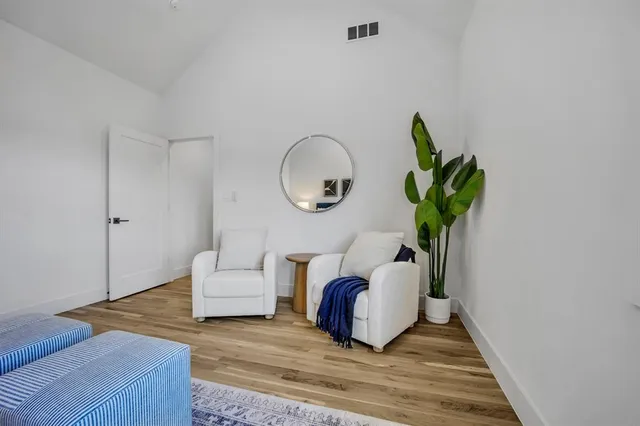 a living room with furniture flowerpot and wooden floor