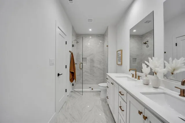 a spacious bathroom with a double vanity sink mirror double and shower
