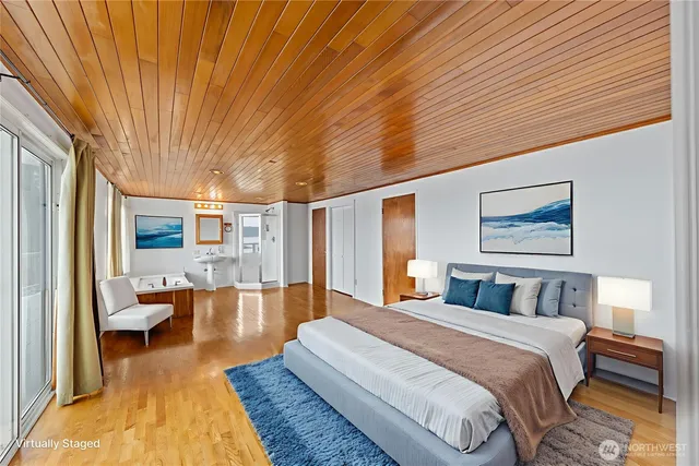 a spacious bedroom with a large bed and a chandelier