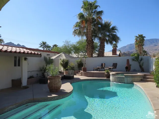 a view of a house with backyard sitting area and garden