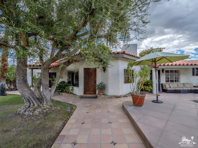 a view of a patio with table and chairs potted plants with large tree