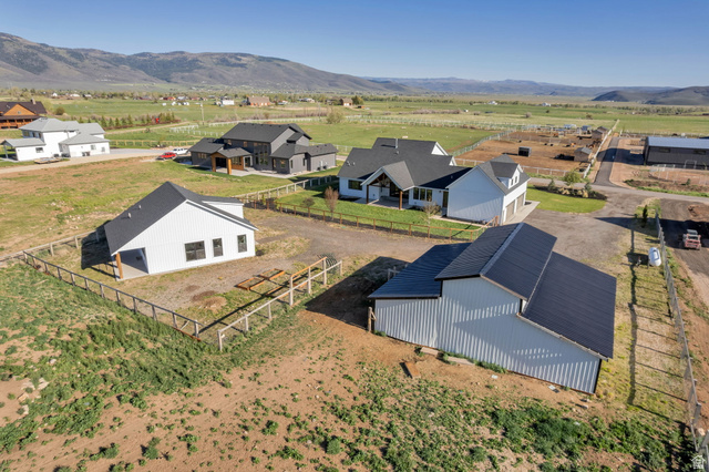 1820 West Farmhouse Flats Road Peoa, UT 84061 - Photo 78 of 79 Property features two structures with white siding and dark roofs, surrounded by a wood fence