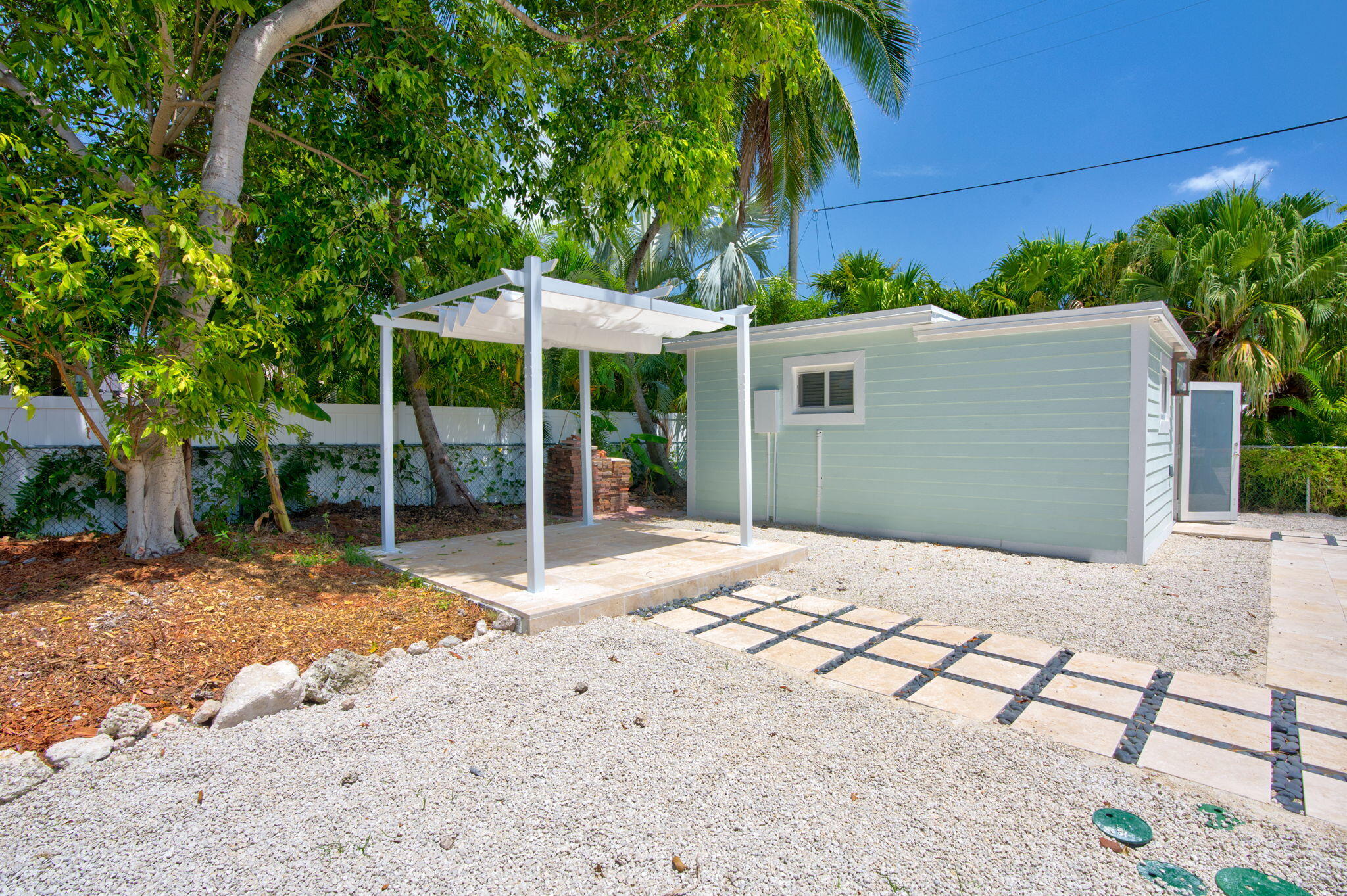 15 Seaside Avenue Key Largo, FL 33037 - Photo 28 of 39 a backyard of a house with table and chairs