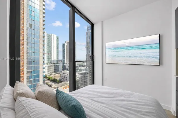 a bedroom with a large window and a bed