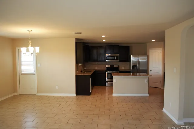 a kitchen with stainless steel appliances granite countertop a refrigerator and a stove top oven