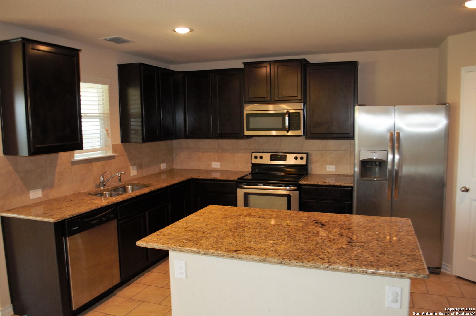 1623 Tree San Antonio, TX 78245 - Photo 6 of 21 a kitchen with kitchen island a sink stainless steel appliances and cabinets