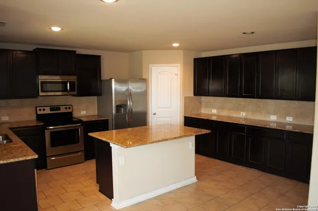 a kitchen with granite countertop stainless steel appliances and wooden cabinets