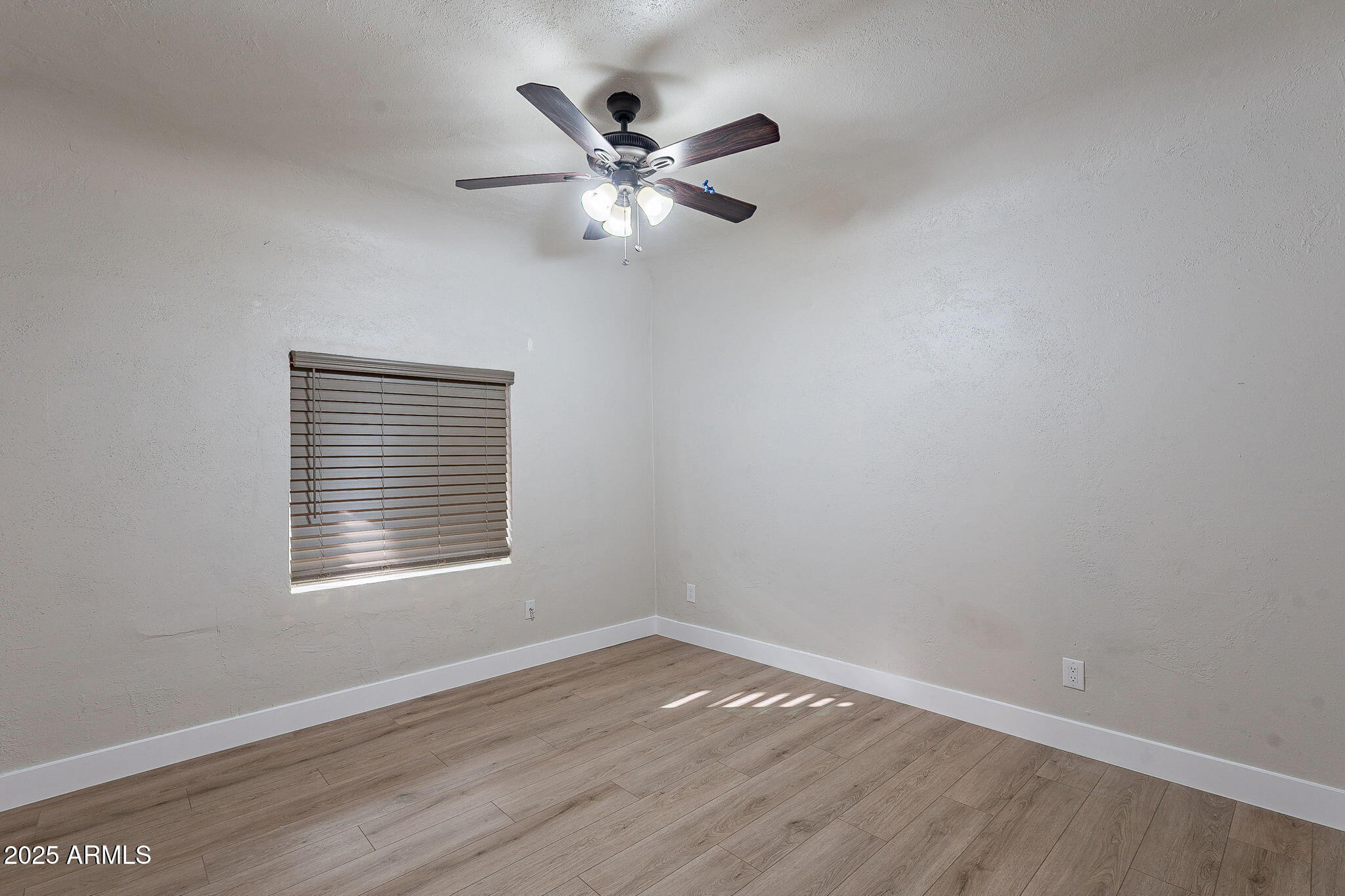 745 East Pierce Street Phoenix, AZ 85006 - Photo 20 of 39 a view of an empty room with wooden floor and a window