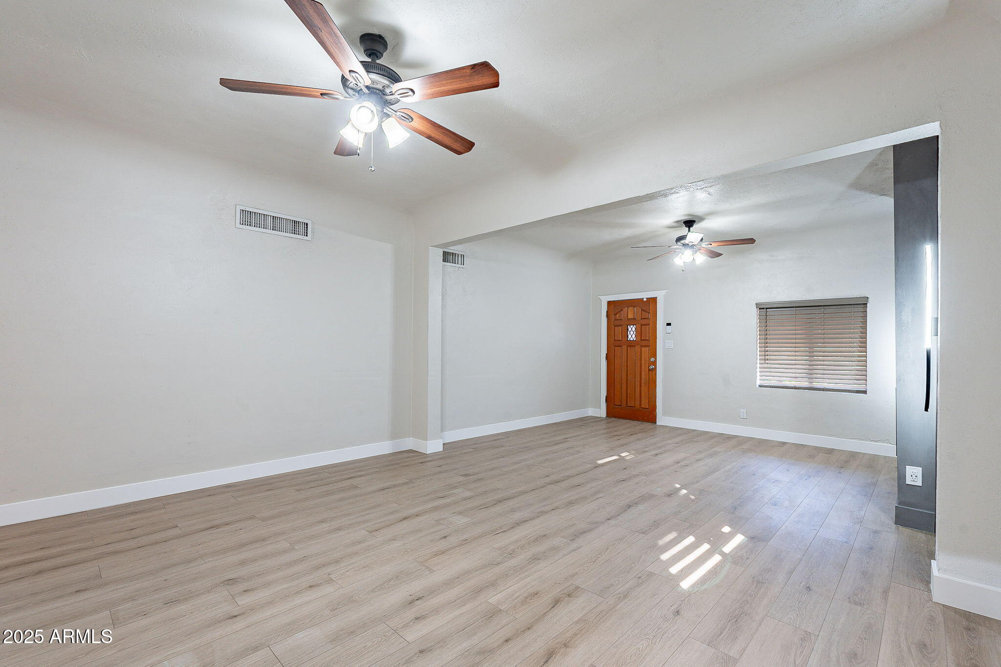 745 East Pierce Street Phoenix, AZ 85006 - Photo 8 of 39 an empty room with wooden floor chandelier fan and windows