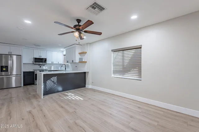 a kitchen with stainless steel appliances a sink cabinets and wooden floor